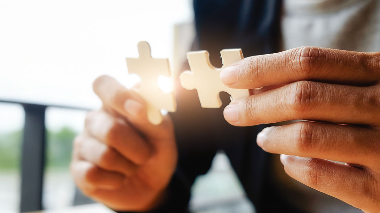 Business woman hands connecting jigsaw puzzle. Business solutions, success and strategy concept. Businessman hand connecting jigsaw puzzle.Close up photo with selective focus.
